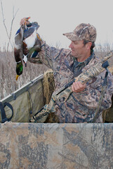 A waterfowl hunter with a mallard and a wood duck 