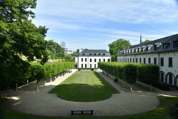 Obraz premium La pelouse principale entre deux rangées de platanes et les bâtiments historiques de l'abbaye de la Cambre à Bruxelles
