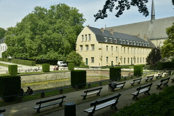 Les bancs en rangées dominant la pièce d'eau et les jardins entre les bâtiments historiques de l'abbaye de la Cambre à Bruxelles