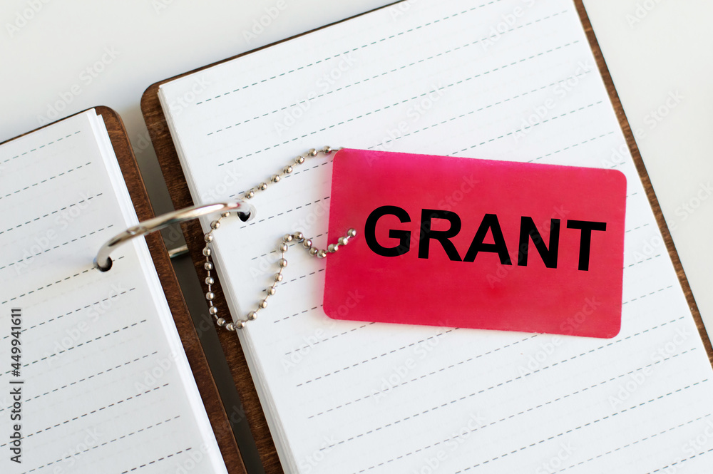 Poster text on the grant business card on an open notebook on the table