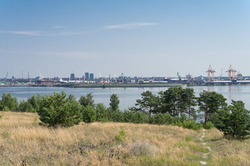 Obraz premium Klaipeda Lithuania - July 14 2021: Narrow strategical gulf between Nida peninsula(Curonian Spit) and mainland Klaipeda harbor full of sailboats, yachts, cargo ships and cruisers.