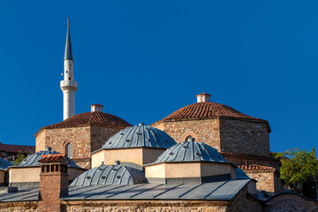 Domes of the historical Turkish bath with a minaret in the background, in Prizren, Kosovo - obrazy, fototapety, plakaty