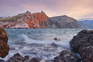 Storm in a sea bay during a wonderful dawn: Black Sea, mountain, rocks, waves.