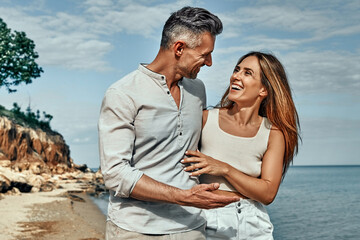 Attractive couple embracing on the beach on a sunny day.