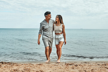 Beach couple walking on romantic travel honeymoon vacation. Summer holidays romance.