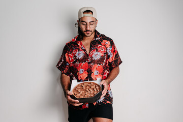 Male model with cap and glasses showing chocolate pizza.