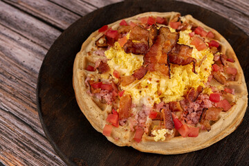 Waffle with eggs, cheese, tomato and bacon