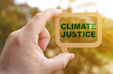 A man holds a sign inside which the inscription - Climate justice