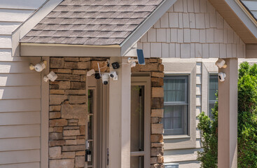 Modern entrance door of home surrounded by security video cameras and sensors for protection...
