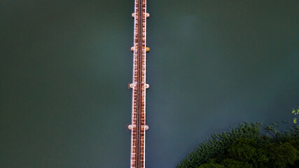 Iron steel frame construction of narrow gauge railway bridge across the river or lake. Bridge with...