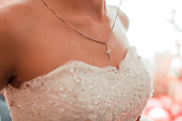 gold cross on the bride's chest
