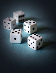 Five dice on a textured teal board.  Dramatic edit.