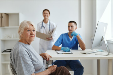 Obraz premium elderly woman patient in hospital nurse and doctor