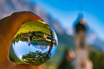 Crystal ball alpine landscape shot with a church and the famous Zugspitze summit at Grainau near Garmisch Partenkirchen, Bavaria, Germany