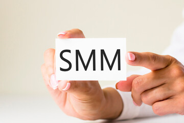 phrase SMM - social media marketing - written on a white paper card