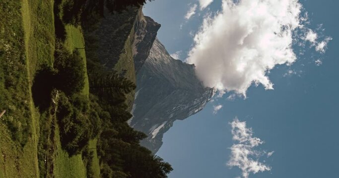 Vertical video - Banner shaped clouds on Matterhorn peak from Blatten meadows