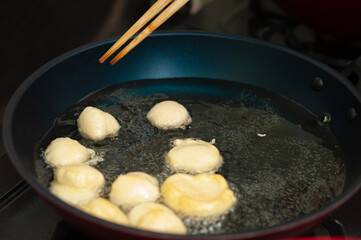 Delicious and traditional Brazilian homemade sweet called BOLINHO DE CHUVA being fried in a frying...