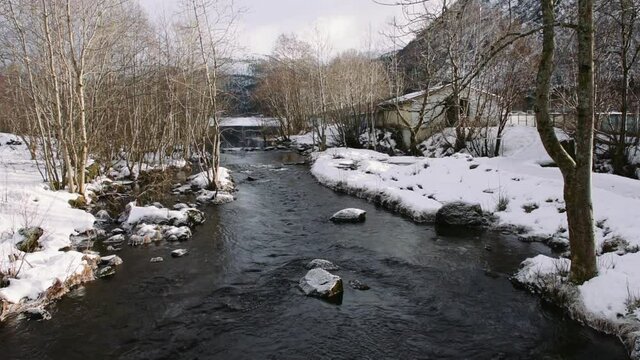 A beautiful winter day in Volda, Norway with a river streaming through snowy lands