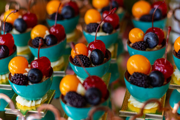 Algumas frutas em mesa de buffet - cereja, amora, physalis, mirtilo.