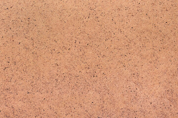 A sheet of hardboard covered with small dots, scratches and inclusions. Cardboard mottled heterogeneous texture.