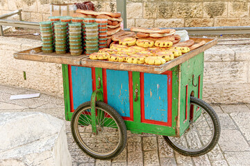 Sweet buns and spices are on display for sale on a colorful, street vendor cart in Old City, Jerusalem, Israel.