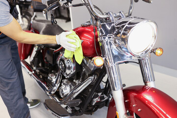 Man cleaning motorcycle in service center closeup