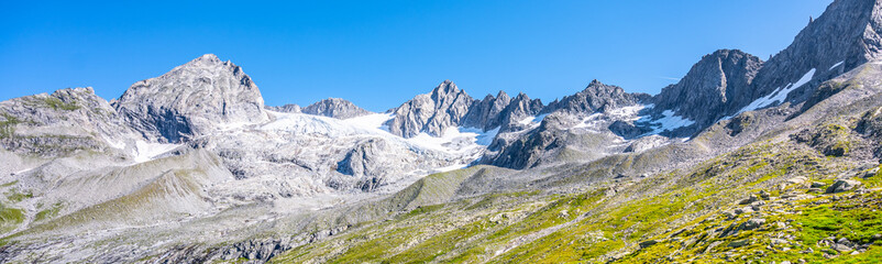 Summer alpine peaks with melting glacier on sunny day. Reichenspitze ridge in Zillertal Alps, Austria