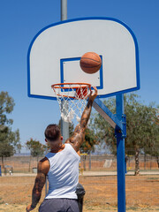 Hombre joven con tatuajes  jugando a baloncesto 