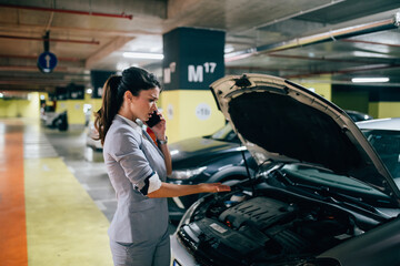 Frustrated and distressed woman has a car failure at public place in underground garage.