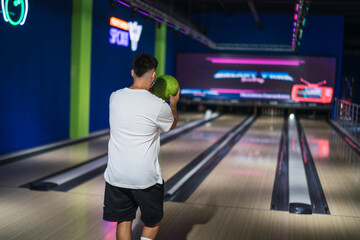 Chico joven jugando a los bolos con mascarilla por covid 19