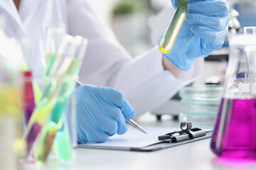 Fototapeta premium Researcher records data obtained from chemical experiment in laboratory