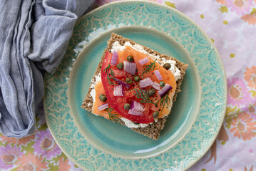 Top View of a Delicious Breakfast/Brunch of Lox Salmon Toast with Capers, Tomatoes, Dill, Red Onion and Cream Cheese.