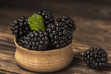 Mulberries on the table in a wooden bowl