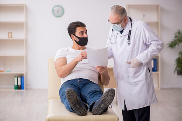 Obraz premium Young male patient visiting old doctor in vaccination concept