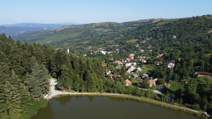 Panorama with lake, hills, forest and village. Rosia Montana Village.