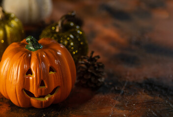 Small multi-colored pumpkins. one pumpkin in the shape of a head with a smile. There are cones nearby. The background is a cozy woolen blanket. Thanksgiving Day. Halloween.