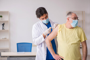 Old male patient visting young male doctor in vaccination concep