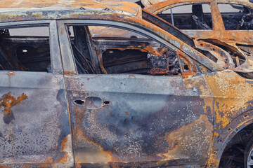 Burnt-out rusty cars on a city street, vandalism. Setting fire to cars by vandals and damage to property