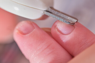 Cutting nails with special scissors on the fingers of a newborn baby, children manicure and cutting burrs