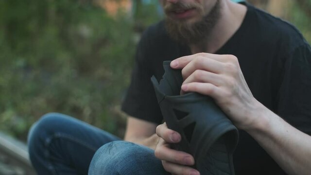 Homeless man showing his completely worn down footwear, flip flops. broken down person, gotten into poverty, misery, been laid off, fired, sacked, burned out. social problems, unemployment concept.