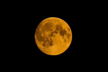 Closeup shot of the golden moon at the midpoint of a black background
