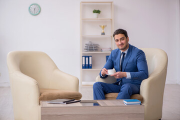 Young male employee waiting for business meeting