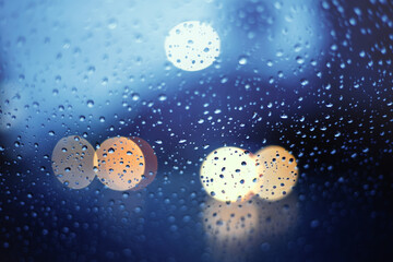 Blurry of street life at night with bokeh light.View through the wind shield during hard rain fall with selective focus.