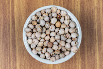 pigeon pea or tuvar beans or guandu bean (Cajanus cajan) seeds in ceramic bowl on the wooden table in Brazil