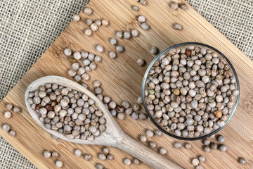 pigeon pea or tuvar beans or guandu bean (Cajanus cajan) seeds in transparent glass bowl and spoon on the wooden table in Brazil