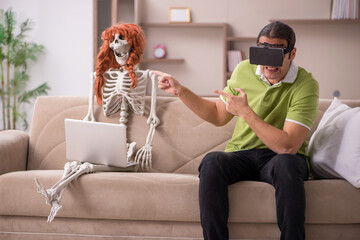 Young man with female skeleton in virtual reality concept