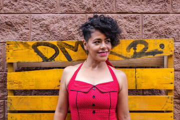 Mid adult afro mexican smiling woman wearing a red dress