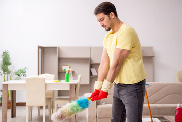 Young male contractor cleaning the house