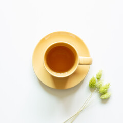 Cup of tea with dry flower on white background. top view, copy space