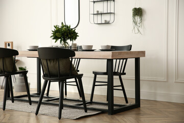 Stylish wooden dining table and chairs in room. Interior design